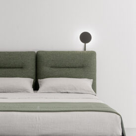 Detalle de respaldo textil con forma cuadrada en cama de matrimonio de diseño, con soporte para luz añadido