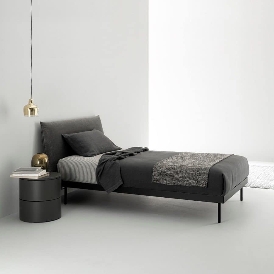 Exclusiva cama simple con cabecero negro acompañada de una funcional y elegante mesita de noche en color negro