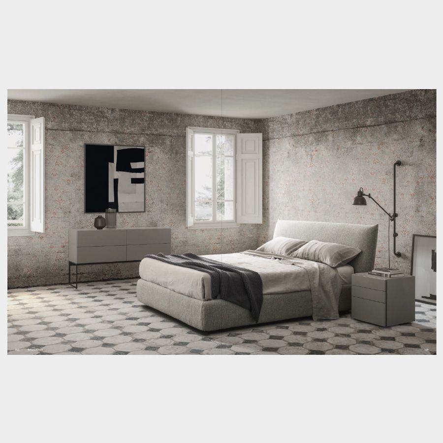 Dormitorio minimalista con cama de diseño italiano junto a cajoneras en tonos neutros, una de ellas funcionando como mesita de noche
